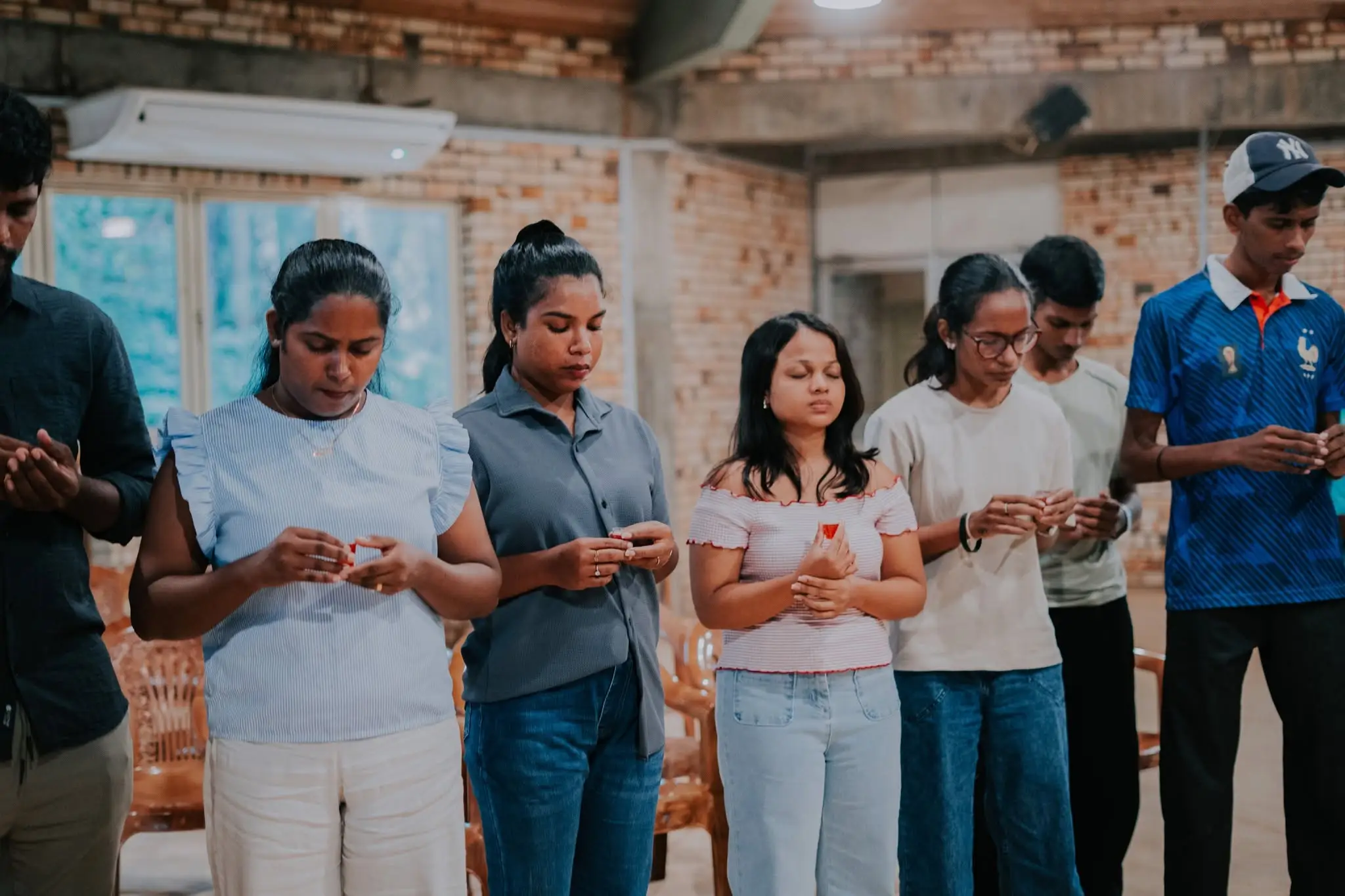 A row of people standing together, each holding communion