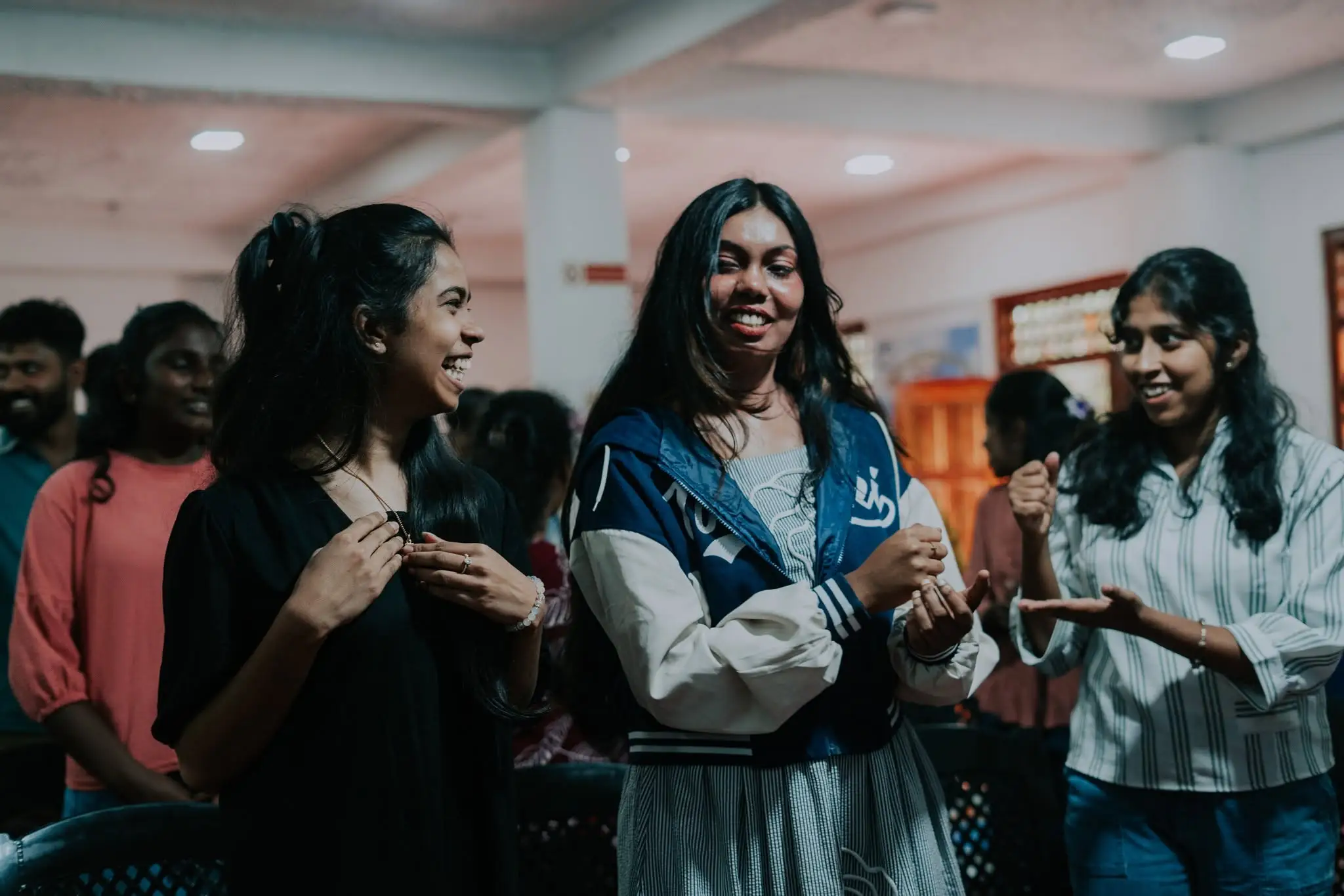 Three young women talking and laughing together after a gathering